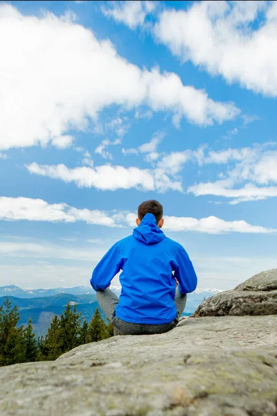 Harika bir dağ yerinde yoga yapan genç adam, yeni bir çağ, enerji, meditasyon ve sağlık, lotus pozisyonunda gülümseyen genç adam.