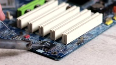 Lehim anakart. Mühendis lehim, büyüteç altında bir çip seti. Elektronik bakım mühendisi. Elektronik bileşenler