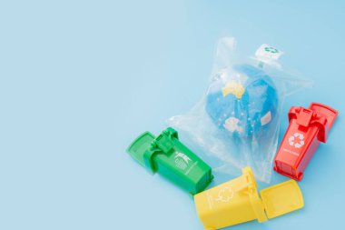 Sarı, yeşil ve kırmızı geri dönüşüm kutularında mavi arka planda geri dönüşüm sembolü var. Şehri düzenli tutar, geri dönüşüm sembolünü bırakır. Doğa koruma kavramı.