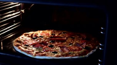 Sıcak fırında İtalyan pizzası pişirmek. Pizzanın yakın çekim zamanı. Fırında pizza pişiriyorum. Ev yapımı fırın konsepti. Yemek pişirme konsepti