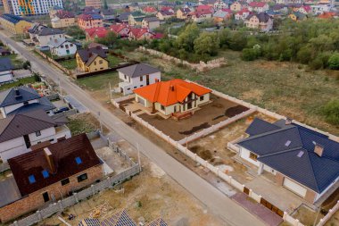 Asfaltlı, yeşil çimenli çimenli, beton zeminli bir evin havadan görünüşü.