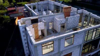 Beyaz köpük beton bloklardan yapılmış inşaat halindeki bir evin inşaatı. Yeni ev çerçevesi oluşturuluyor