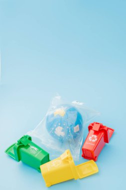 Sarı, yeşil ve kırmızı geri dönüşüm kutularında mavi arka planda geri dönüşüm sembolü var. Şehri düzenli tutar, geri dönüşüm sembolünü bırakır. Doğa koruma kavramı.