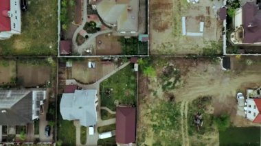 Konut arazilerindeki evlerin havadan görünüşü, kimisi çatı panelleri olan evler..