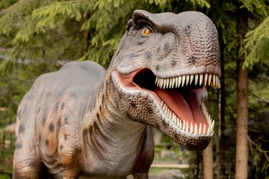 Orman parkındaki dinozor heykeli, arka plandaki dinozor heykeli.