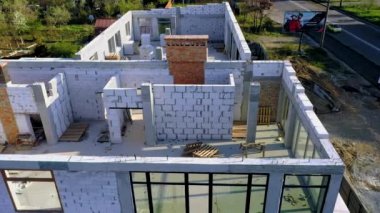 Beyaz köpük beton bloklardan yapılmış inşaat halindeki bir evin inşaatı. Yeni ev çerçevesi oluşturuluyor