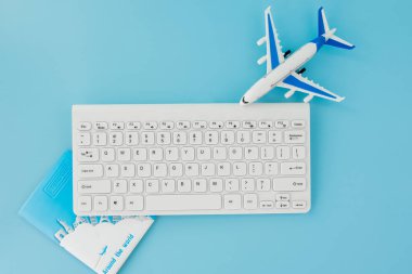 Uçak bileti rezervasyonu ve arama uluslararası seyahat konsepti, klavye, pasaport ve mavi arka planda uçak. Yaz ya da tatil konsepti. Boşluğu kopyala