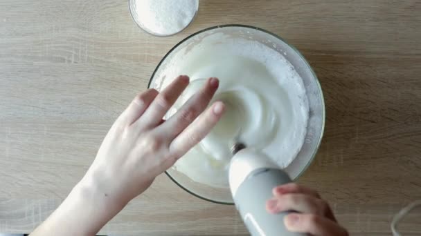 Vrouwelijke Handen Kloppen Eiwit Crème Met Mixer Kom Houten Tafel — Stockvideo