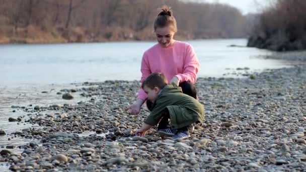 Junge Frau Mit Ihrem Sohn Sammelt Plastikmüll Einem Müllsack Fluss — Stockvideo