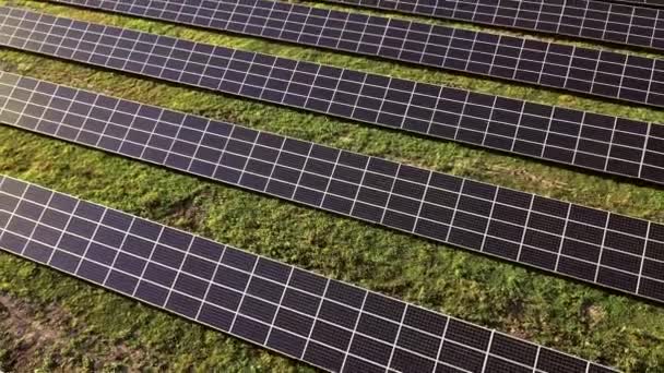 日没の風景でフィールドの緑のエネルギーの行で太陽光発電所のパネルを閉じる電気生態系の革新自然環境 — ストック動画