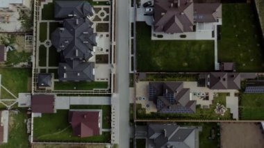 Konut arazilerindeki evlerin havadan görünüşü, kimisi çatı panelleri olan evler.
