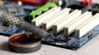 Lehim anakart. Mühendis lehim, büyüteç altında bir çip seti. Elektronik bakım mühendisi. Elektronik bileşenler.