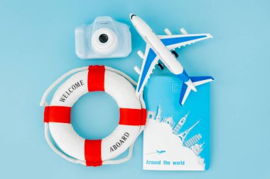 Can simidi, pasaportlar, kamera, mavi arka plandaki uçak modeli. Yaz ya da tatil konsepti. Boşluğu kopyala.