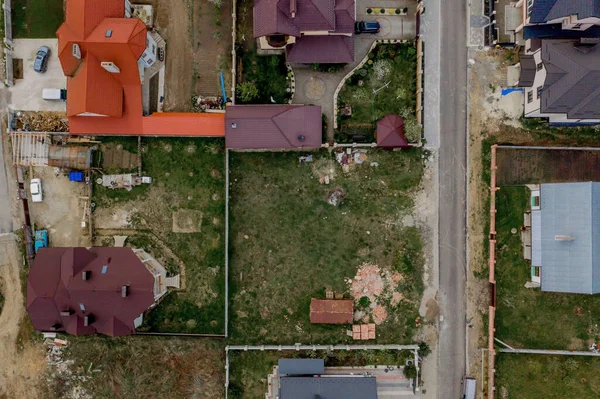 Asfaltlı, yeşil çimenli çimenli, beton zeminli bir evin havadan görünüşü.