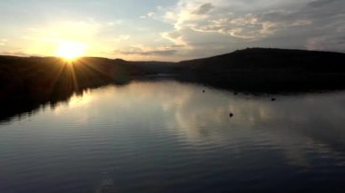 Balıkçının Altın Gün batımı nehrindeki teknedeki görüntüsü. Balıkçıların silueti teknesiyle, balıkçı yaşam tarzıyla.