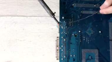 Lehim anakart. Mühendis lehim, büyüteç altında bir çip seti. Elektronik bakım mühendisi. Elektronik bileşenler