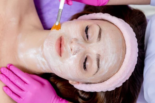 Yüz soyma maskesi, kaplıca güzellik tedavisi, cilt bakımı. Güzellik salonundaki kadın yüz bakımını alıyor, yan görüş, yakın çekim. Yaşlanma karşıtı tedavi. Kozmetoloji ve profesyonel yüz bakımı