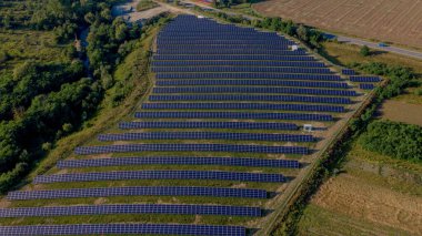 Güneşli bir günde Green Field 'daki Güneş Enerjisi İstasyonu' nun Aerial Top görüntüsü. İnsansız hava aracı Güneş Çiftliği üzerinde uçuyor. Bir sürü Güneş Paneli Güç Üretimi için sırada bekliyor. Yenilenebilir yeşil enerji