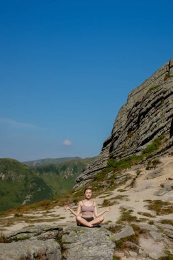 Yoga, meditasyon. Kadın dengeli, meditasyon yapıyor ve dağlarda zen enerjisi yogası yapıyor. Sabahları dışarıda spor yapan bir kız. Sağlıklı yaşam tarzı kavramı