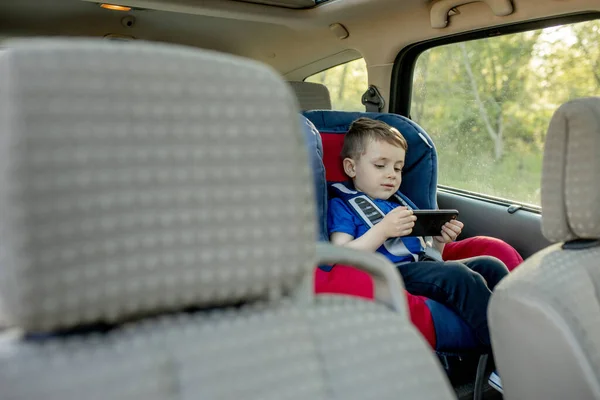 Πορτρέτο Ενός Βαριεστημένου Αγοριού Που Κάθεται Ένα Κάθισμα Αυτοκινήτου Ασφάλεια — Φωτογραφία Αρχείου