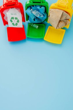 Sarı, yeşil ve kırmızı geri dönüşüm kutularında mavi arka planda geri dönüşüm sembolü var. Şehri düzenli tutar, geri dönüşüm sembolünü bırakır. Doğa koruma kavramı.