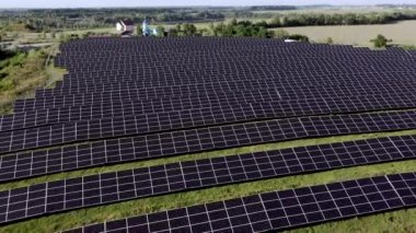 Güneşli bir günde, Yeşil Alan 'daki güneş enerjisi istasyonu. Hava görüntüsü. Güneş Panelleri Güç Üretimi Alanında Bir Satırda Duruyor. İnsansız hava aracı Güneş Çiftliği üzerinde uçuyor. Yenilenebilir yeşil enerji. Alternatif enerji kaynakları