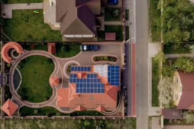 Mavi panelli, yeni, modern bir ev kulübesinin havadan görünüşü. Yenilenebilir ekolojik yeşil enerji üretim kavramı.