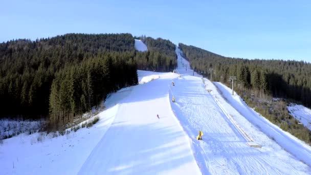 Lot dronem nad grupą osób na nartach w ośrodku narciarskim w sezonie zimowym. Gondola ski snowboard śnieg piękne białe krajobrazy — Wideo stockowe