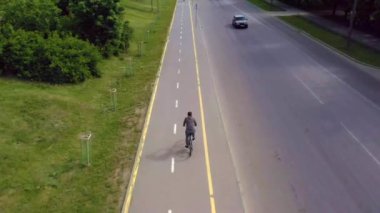 Ivano-Frankivsk, 29 Mayıs 2020: güzel şehir caddesinde bisiklet süren bisikletçinin hava aracı görüntüleri. Atletik antrenman ya da güneşli bir yaz gününde güç egzersizi. Sağlıklı bisiklet yaşam tarzı