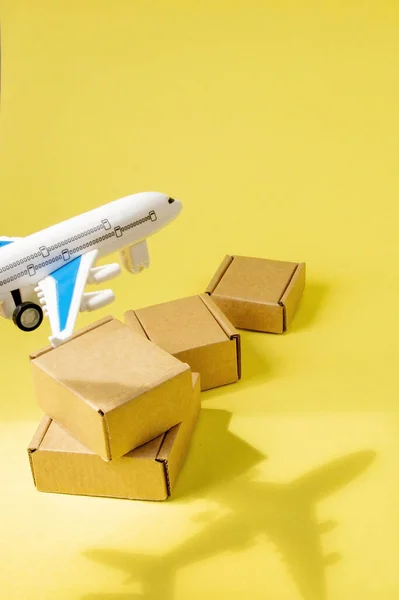 Shadow Airplane and stack of cardboard boxes. concept of air cargo and parcels, airmail. Fast delivery of goods and products. Cargo aircraft. Logistics, connection to hard-to-reach places. Banner, copy space.