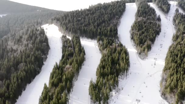 Let dronem nad skupinou lidí lyžujících v lyžařském středisku během zimní sezóny. Gondola ski snowboard sníh krásná bílá scenérie