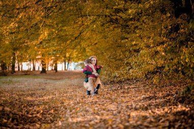 Mutlu genç anne parkta güneş ışığı altında oynayıp, oğluyla eğleniyor. Mutlu aile kavramı.