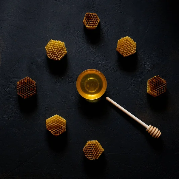 黒のテーブルの上の時計の形で蜂蜜とハニカム トップビュー — ストック写真