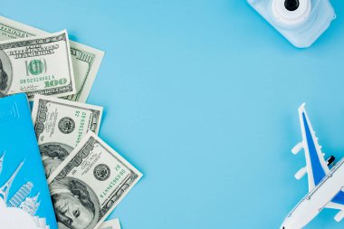 Kamera, pasaport ve uçak açık mavi arka planda. Boşluğu kopyala