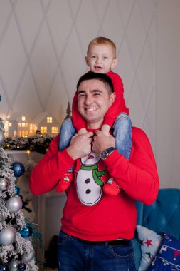 Noel ağacını Noel baloları ve hafif çelenklerle süsleyen mutlu baba ve oğul kış tatillerini kutlamaya hazırlanıyor: Mutlu Noeller ve mutlu yeni yıl 2021. Aile kavramı.