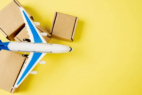 Airplane and stack of cardboard boxes. concept of air cargo and parcels, airmail. Fast delivery of goods and products. Cargo aircraft. Logistics, connection to hard-to-reach places. Banner, copy space.