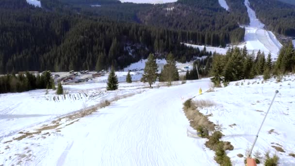 雪の山の斜面や冬の木とスキーリゾートの空中ビュー ストック映像だ ロープウェイの上駅やスキーやスノーボードに行く人々のグループは 丘の下 — ストック動画