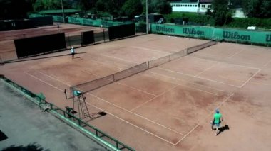 Ukrayna, Kyiv - 4 Nisan 2020: Tenis sahası yukarıdan iki adamla maç yaparken görüldü. Olgun, çevik ve sağlıklılar. İnsansız hava aracı ile yapılan video.