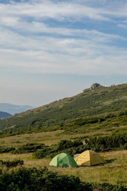 Gün doğumunda ya da günbatımında dağlardaki turistik çadır manzarası. Kamp geçmişi. Macera seyahati aktif yaşam tarzı özgürlük kavramı. Yaz tatili
