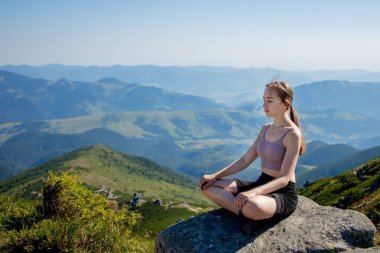 Yoga, meditasyon. Kadın dengeli, meditasyon yapıyor ve dağlarda zen enerjisi yogası yapıyor. Sabahları dışarıda spor yapan bir kız. Sağlıklı yaşam tarzı kavramı