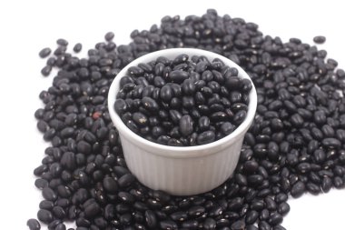 Beyaz arka planda izole bir kasede siyah fasulye.
