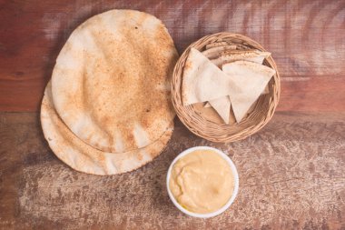 Bir kase ve Arap ekmek ahşap bir masa üzerine nohut humus