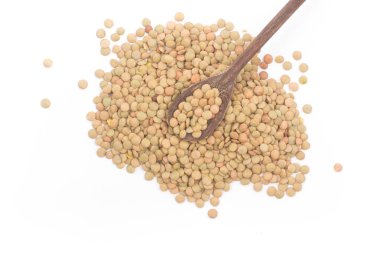 Bir kaşık beyaz arka plan üzerinde izole mercimek yığını