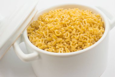 Mektup şeklindeki makarna üzerine beyaz izole bir mini tava