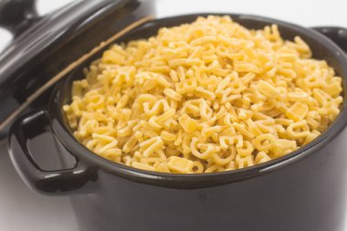 Mektup şeklindeki makarna üzerine beyaz izole bir mini tava