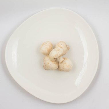 Taze champignon mantar beyaz arka plan üzerinde bir plaka üzerinde