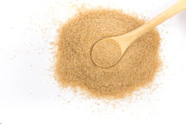 Beyaz arka plan üzerinde izole bir kaşık şeker: demerara yığını. Üstten görünüm