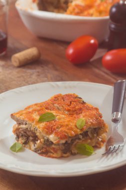 Ahşap bir masa üzerine mantarlı ıspanak lazanya