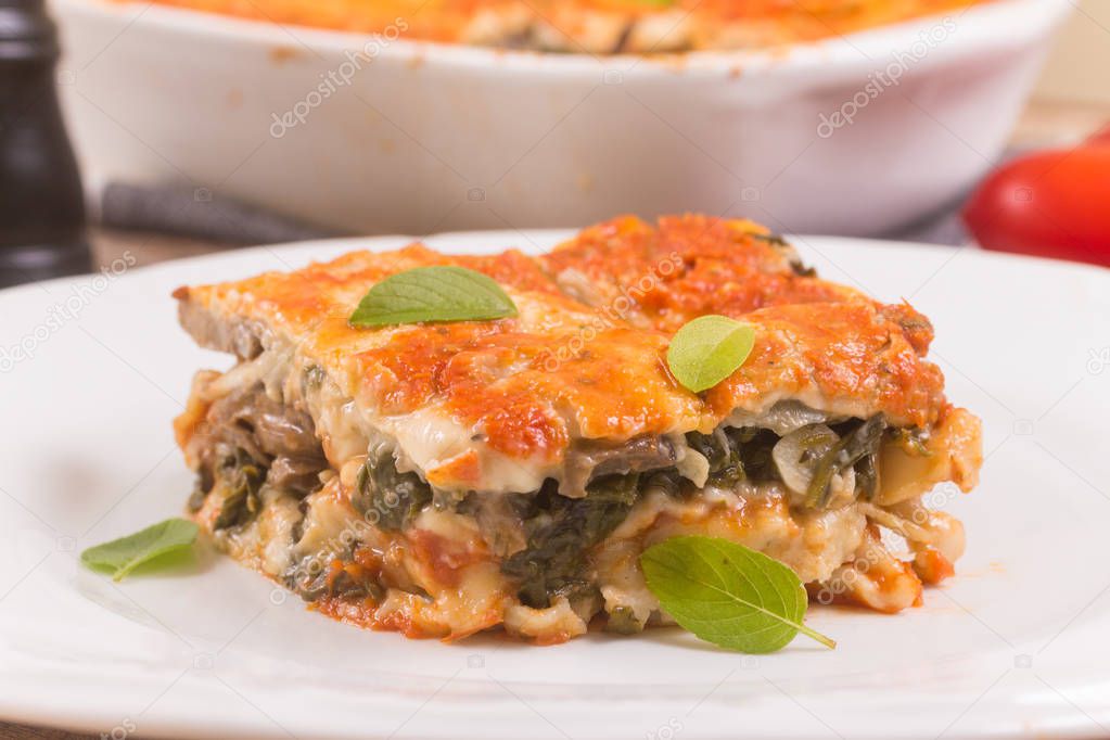 Spinach Lasagna with mushroom over a wooden table