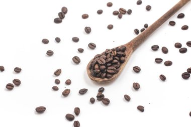 Beyaz bir arka plan üzerine bir kaşık kahve çekirdekleri yığını